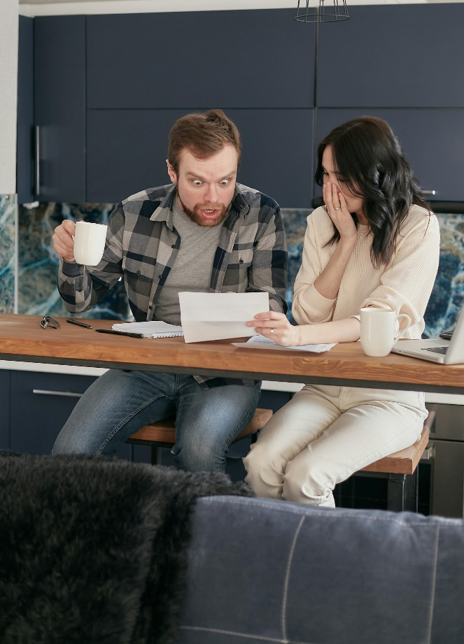 A man and woman sitting at a table with papers.