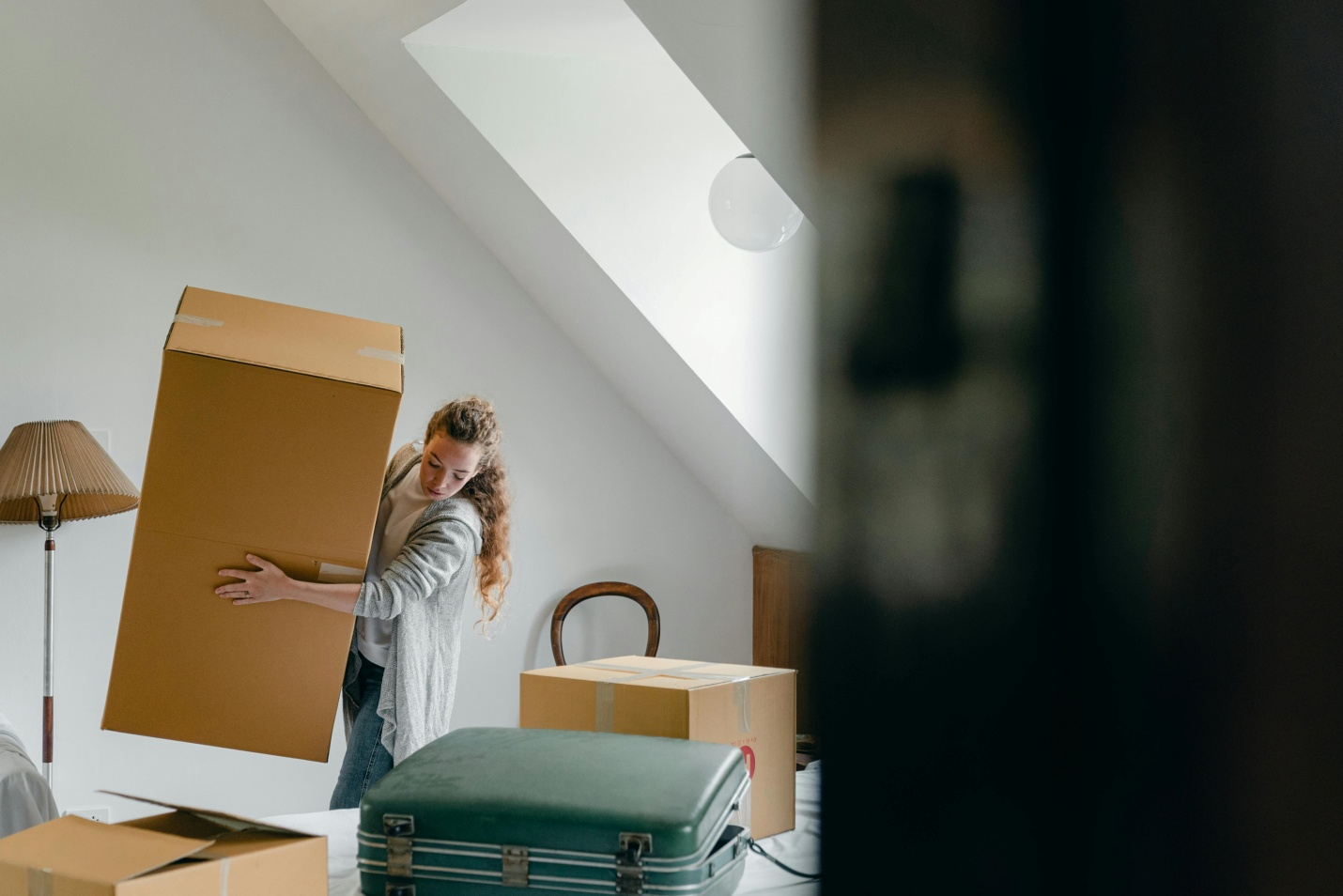 A woman standing in front of boxes and luggage.