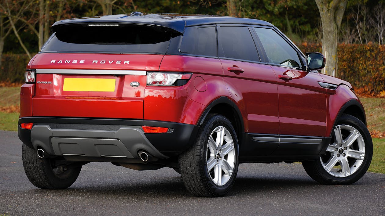 A red range rover parked in the street.