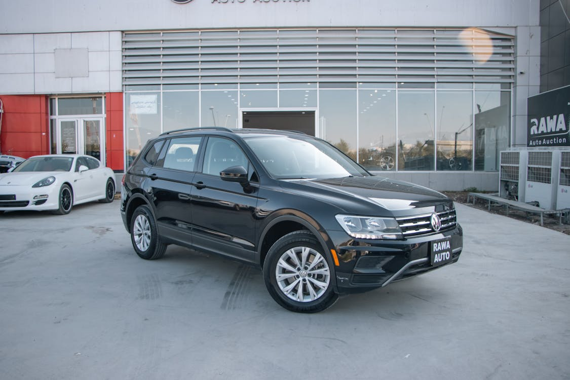 A black volkswagen suv parked in front of a building.