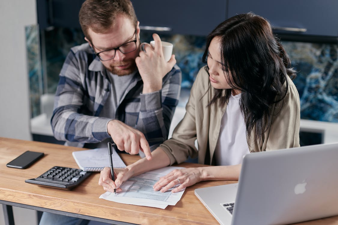 A man and woman are working on papers.