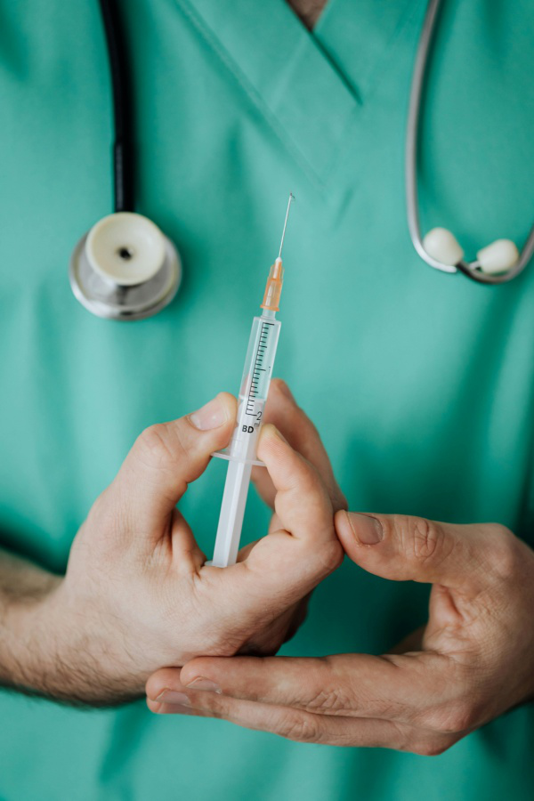 A person holding an injection needle in their hand.