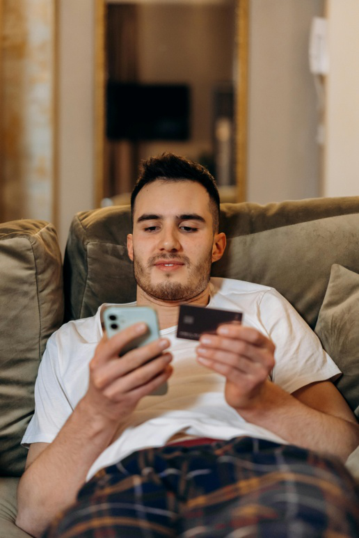 A man sitting on the couch looking at his phone.