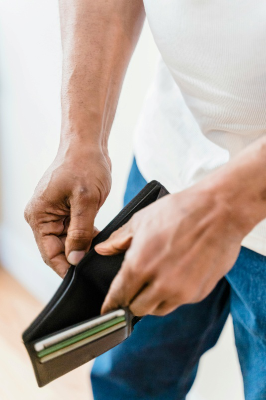 A man is holding his wallet in the hand.