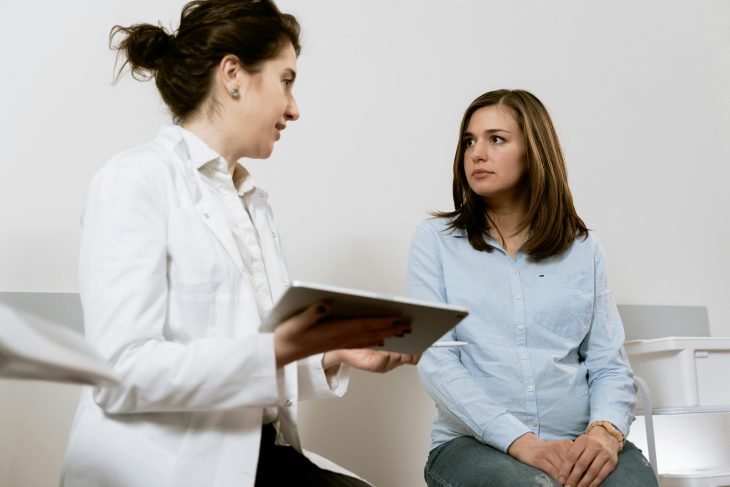 Two women are sitting in a room talking.