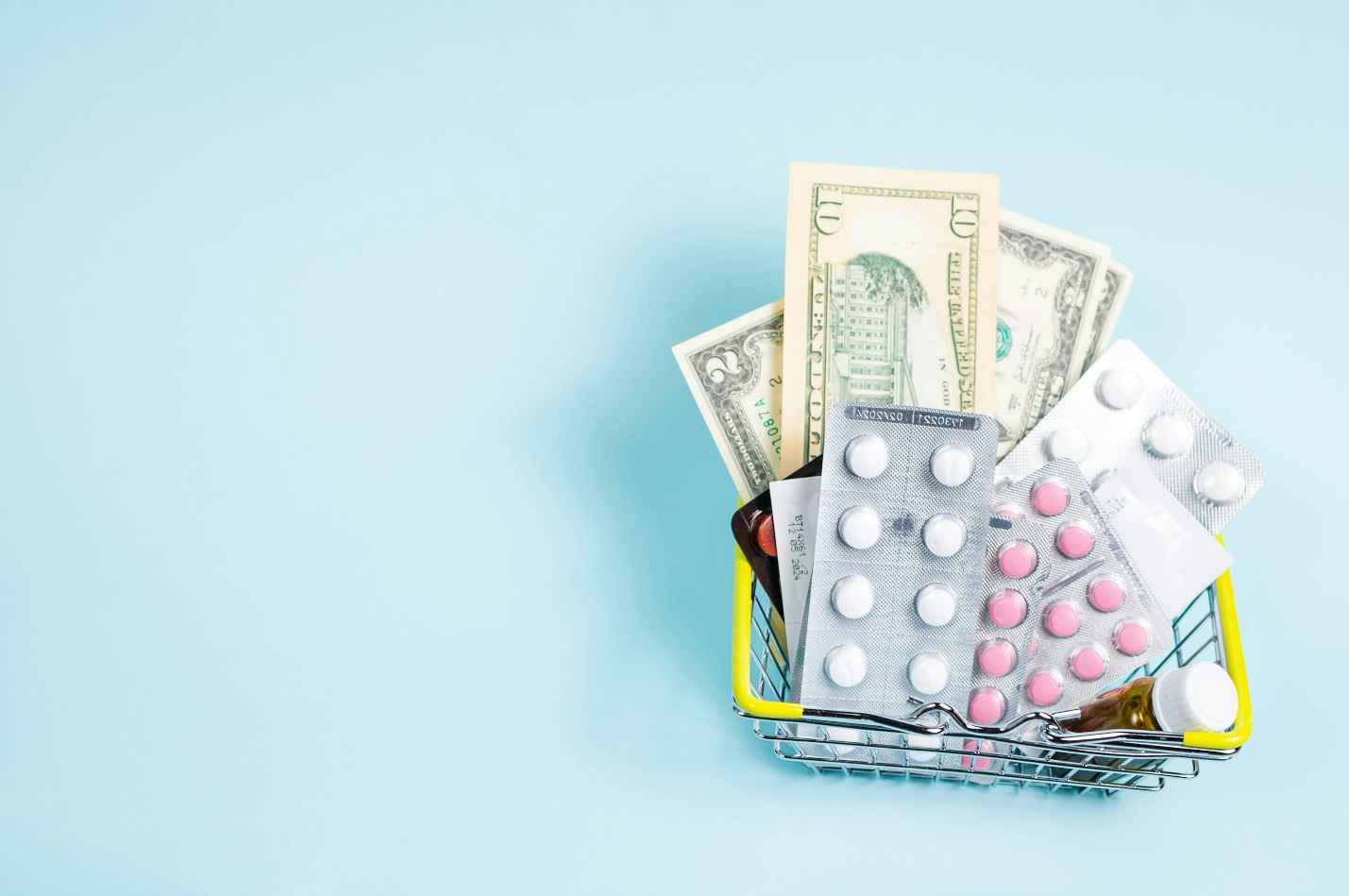 A basket of pills and money on top of a table.