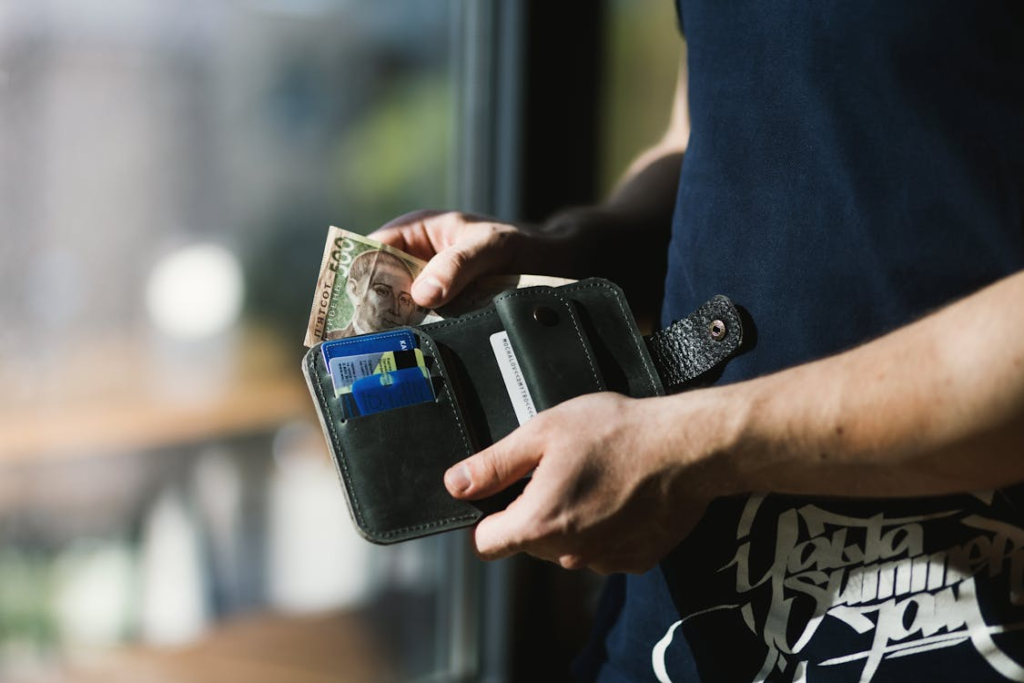 A person holding an open wallet with money in it.