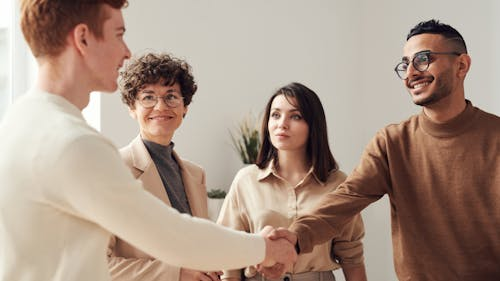 A group of people standing around shaking hands.