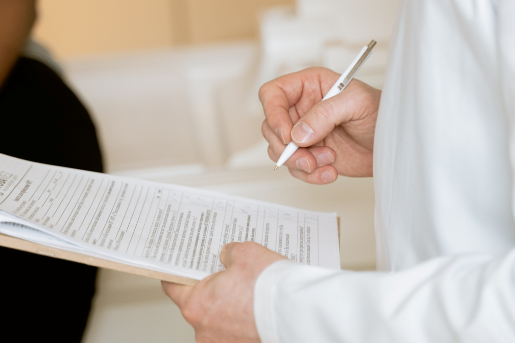 A person signing a document with a pen.