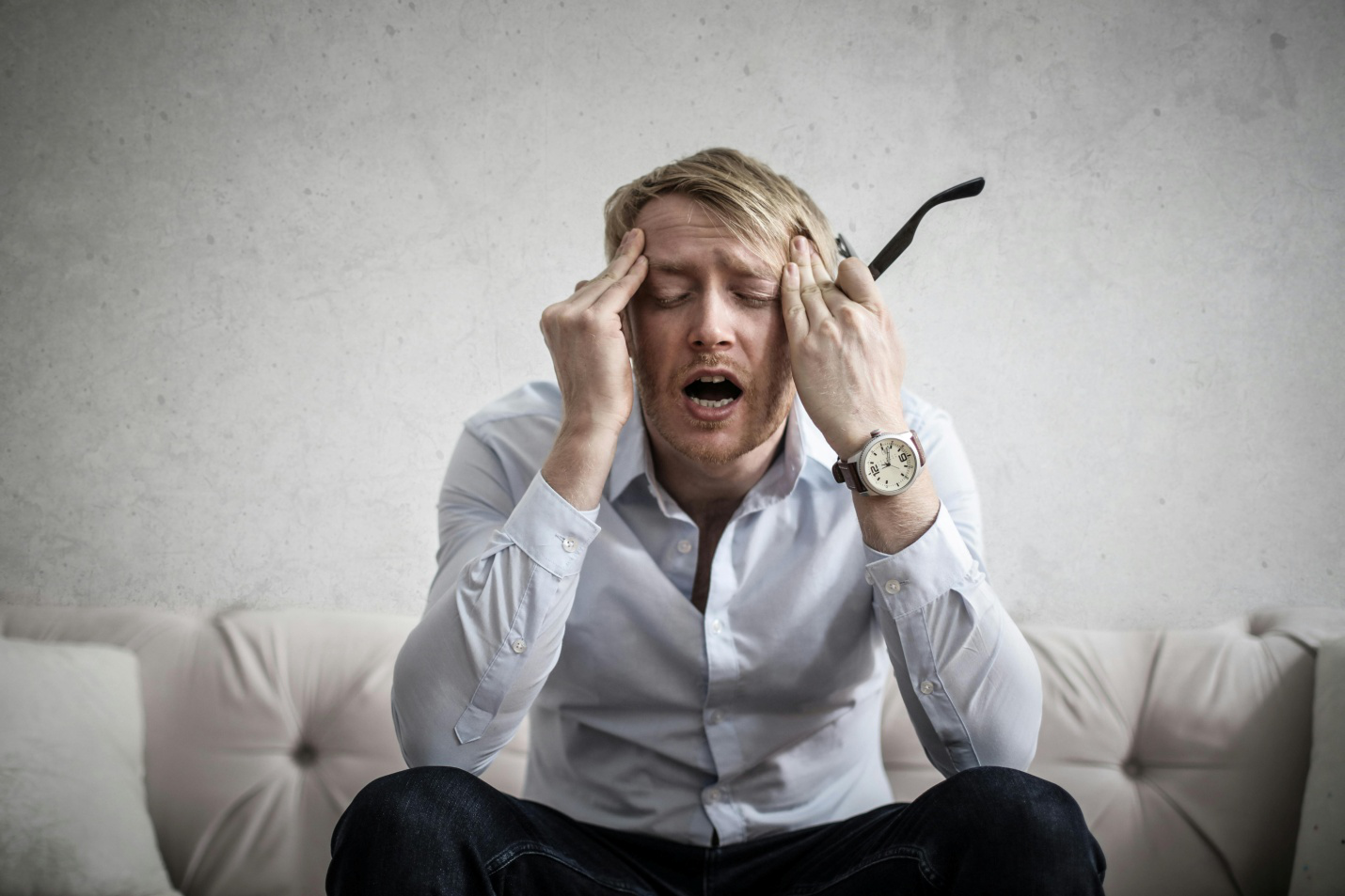 A stressed man holding his head