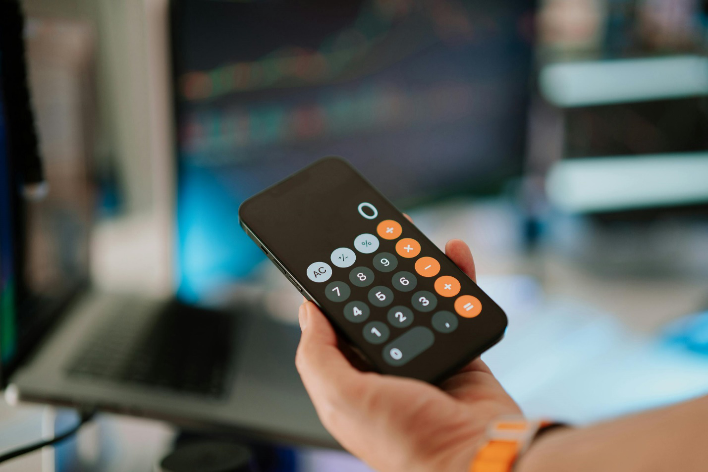  a person holding a phone with a calculator open on it 