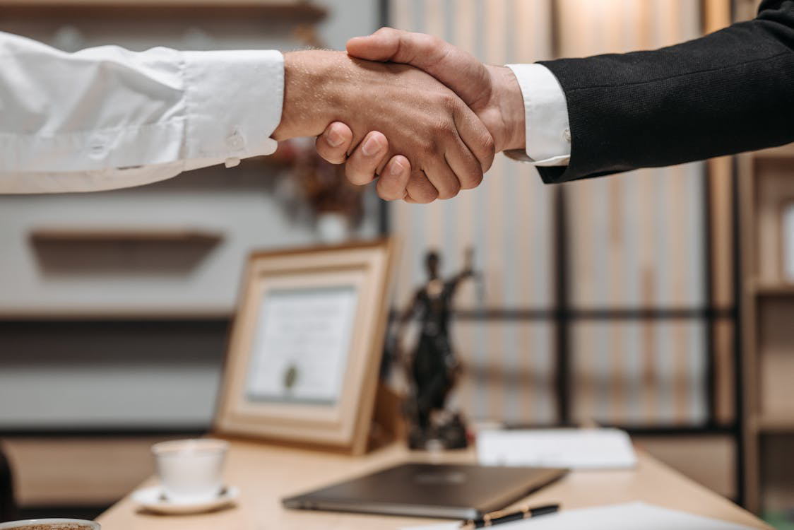  A firm handshake signifies the importance of collaboration in debt relief.