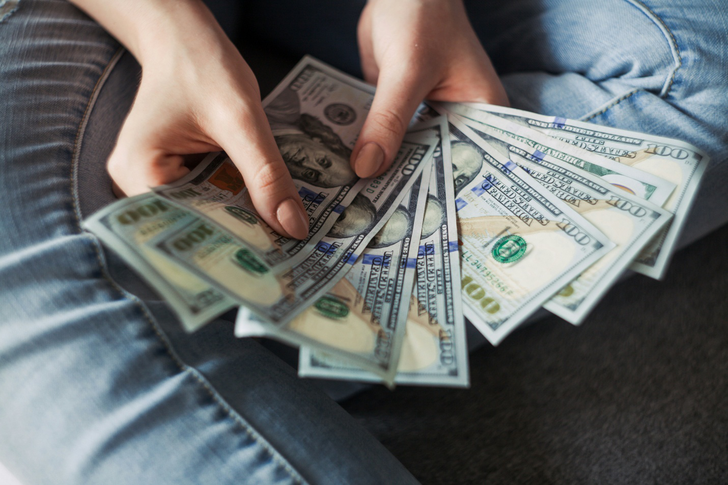 A person counting 100-dollar bills