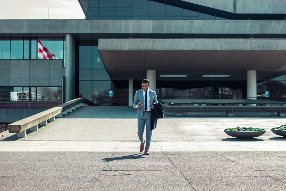 Man walking while holding a black coat