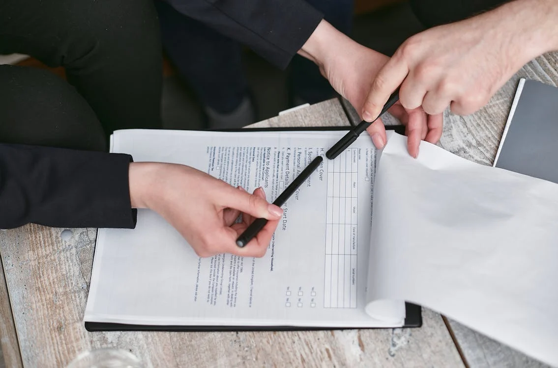 A business contract and pen on a table representing a completed deal