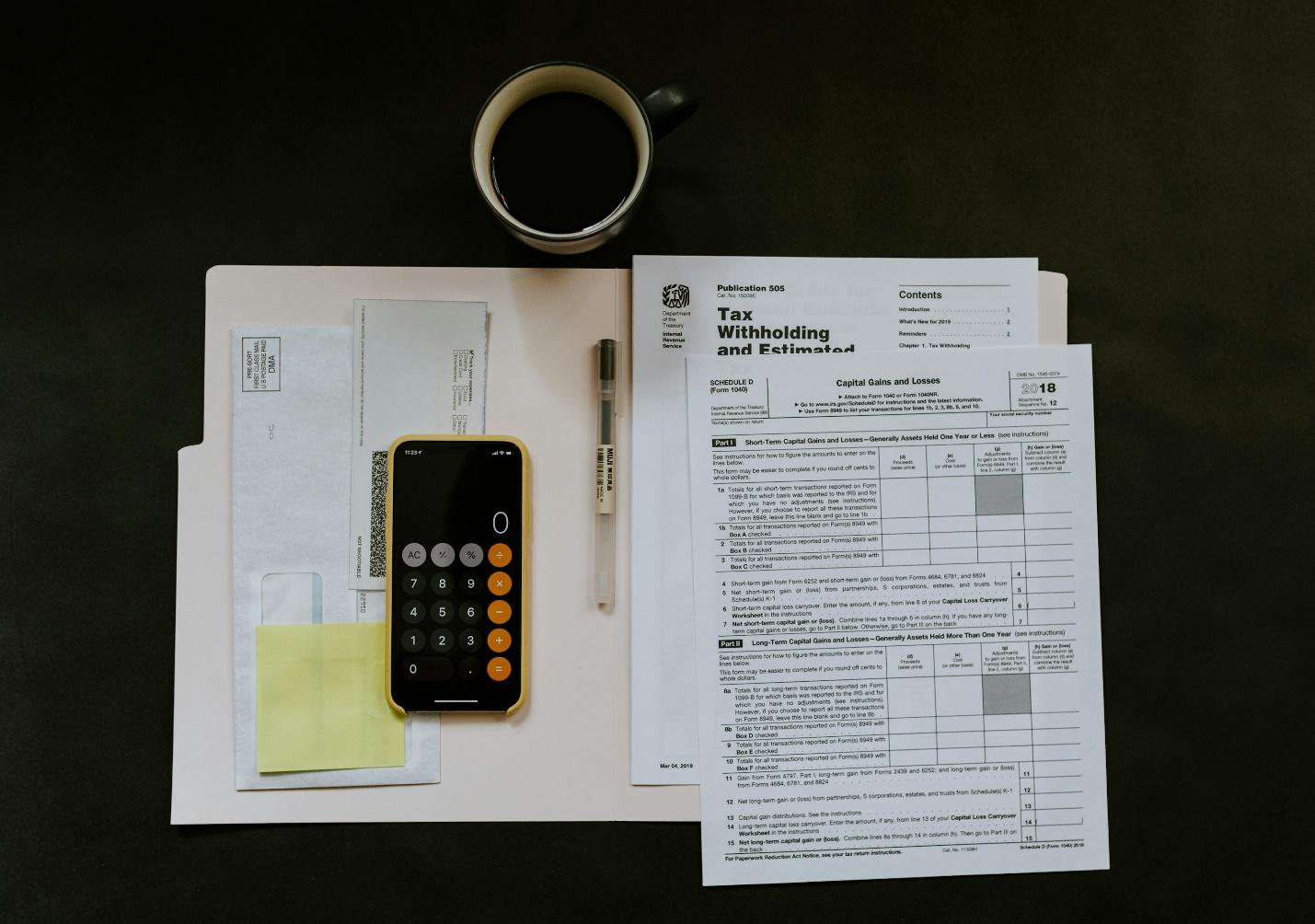 a cup of coffee placed next to tax documentation