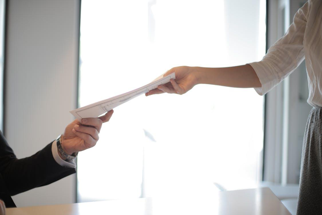 an individual handing over a document 