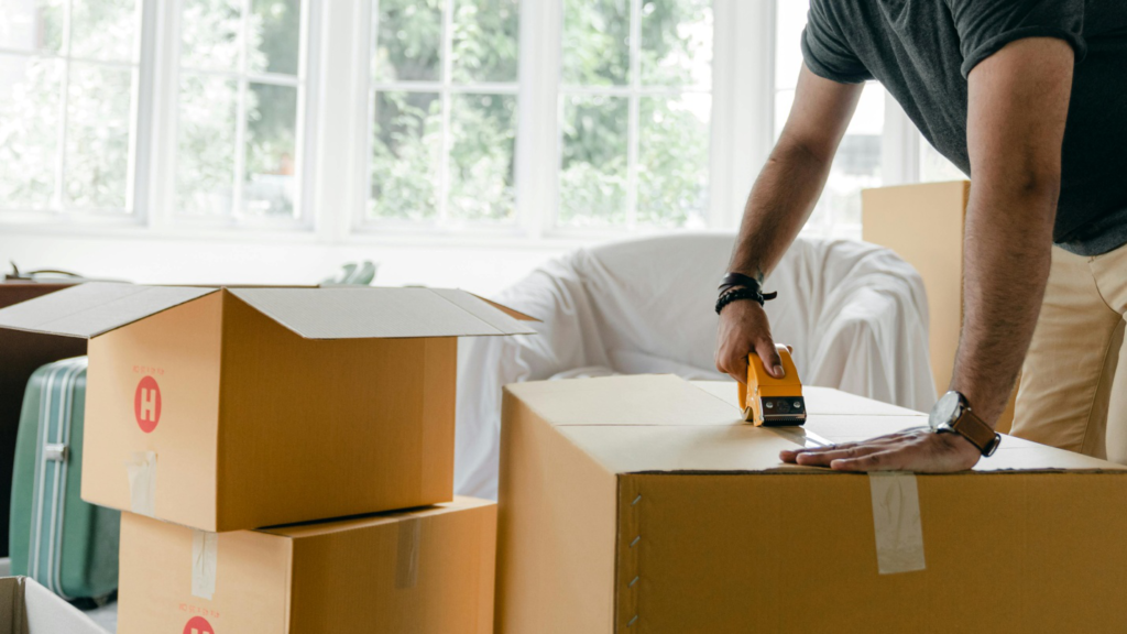 A man packing his stuff in boxes