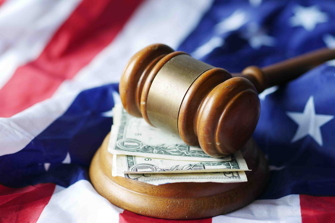 a gavel and dollars placed on the flag of the United States
