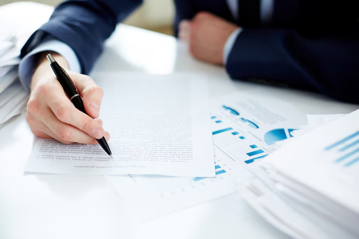 A person holding a pen is reviewing a document