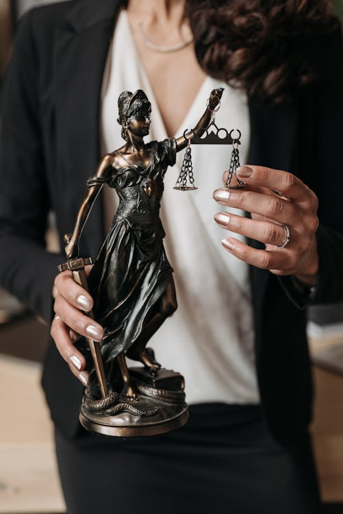 A person holding a statuette of Lady Justice, symbolizing fairness and legal balance.