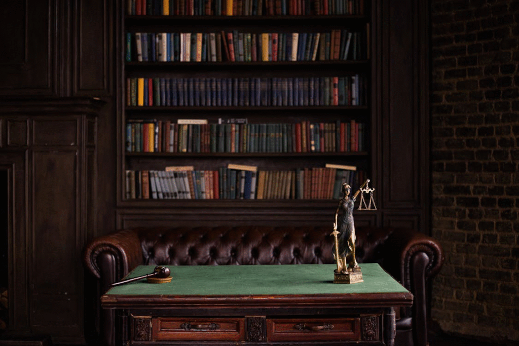Lady Justice statue in front of a bookshelf on a table