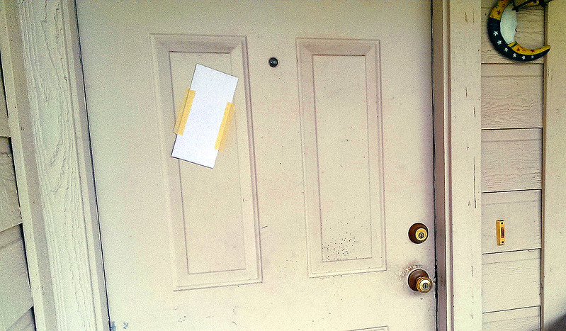 a foreclosure notice posted on a front door