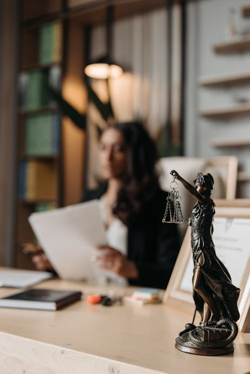 A Lady Justice figurine placed on a wooden office table.