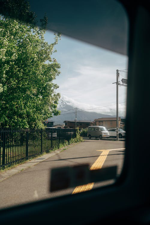 A view of a Japanese city street through a car window from the backseat.