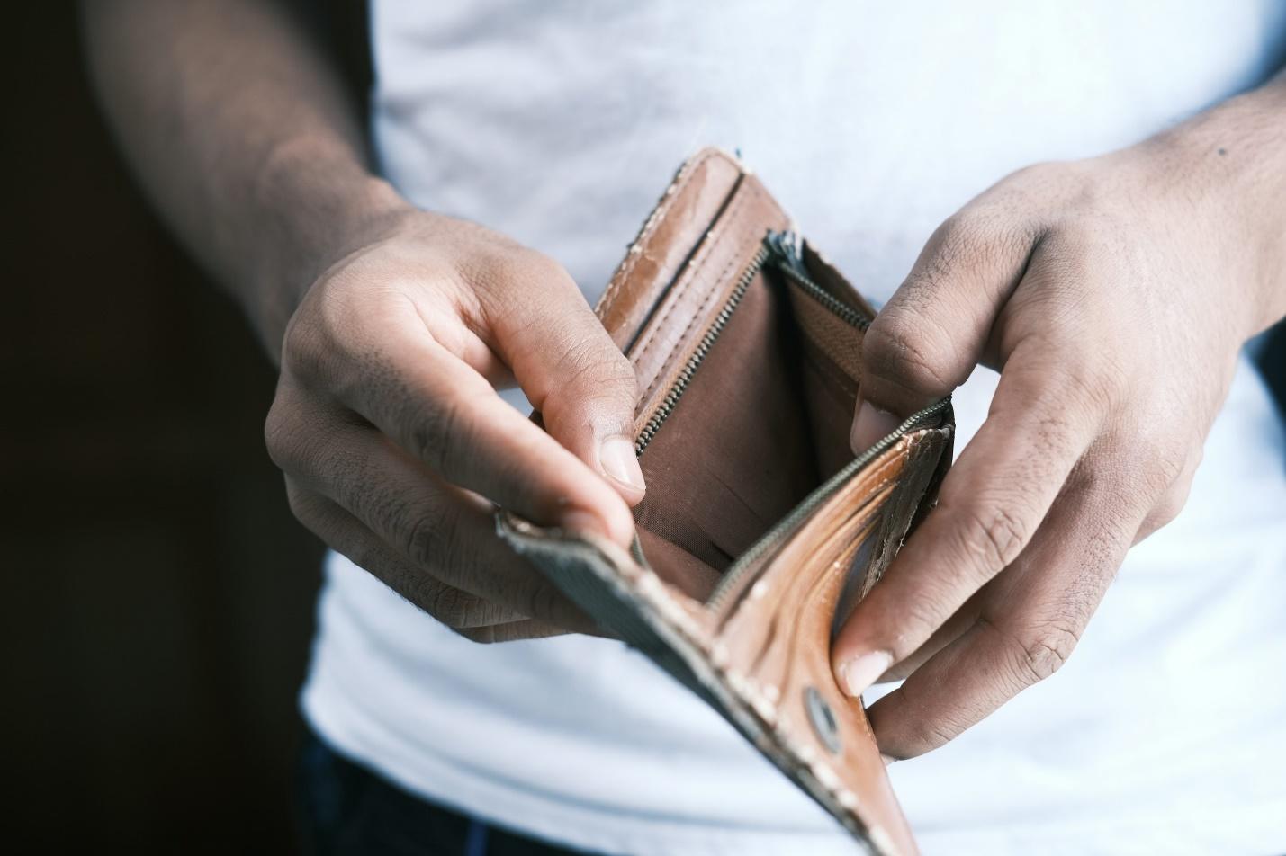 A person looking into an empty wallet