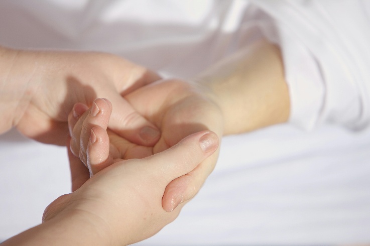 Person holding another person’s hand with both hands