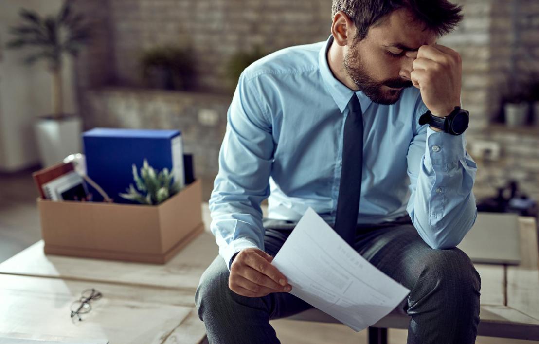 stressed man reading threatening debt collection letter