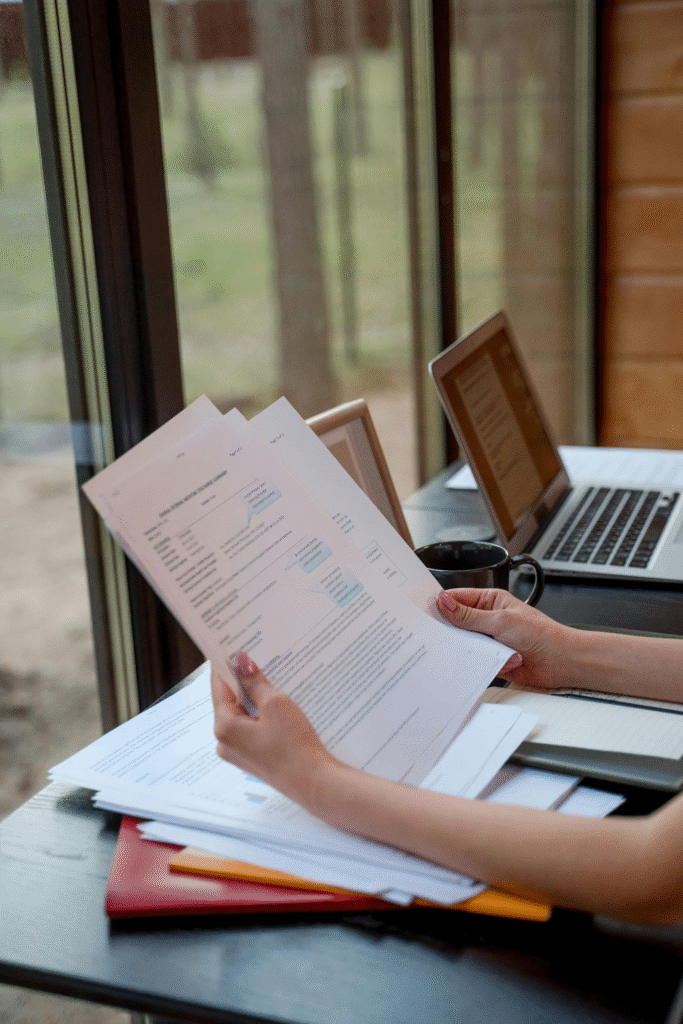a person holding documents on a table