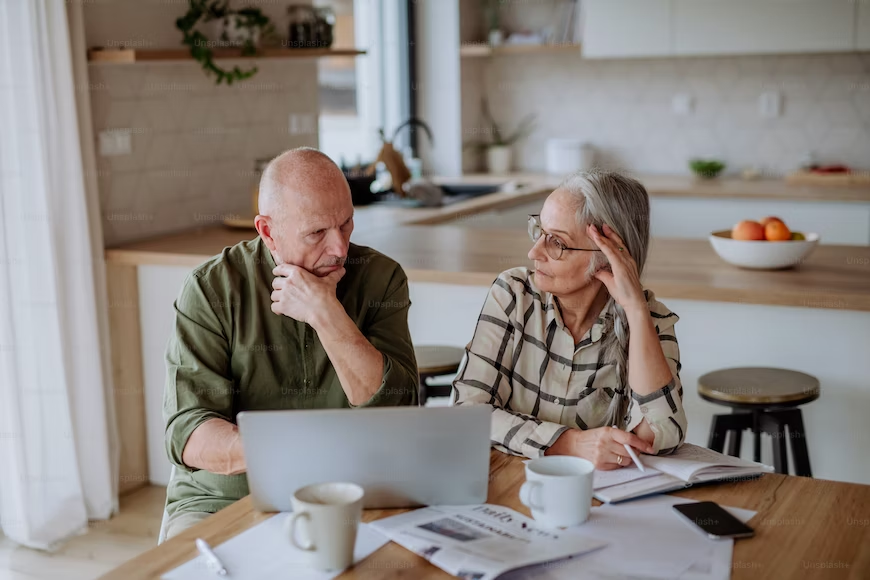 An elderly couple using a laptop