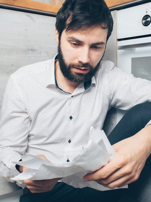 A stressed man reading a car repossession notice