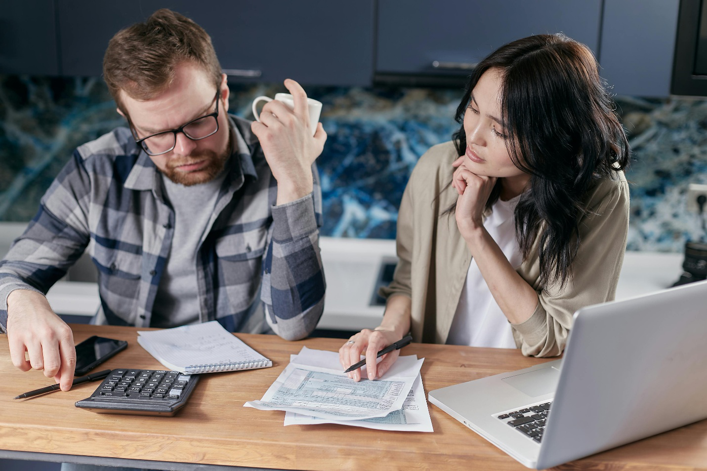 A man and woman sitting at a table reviewing bills