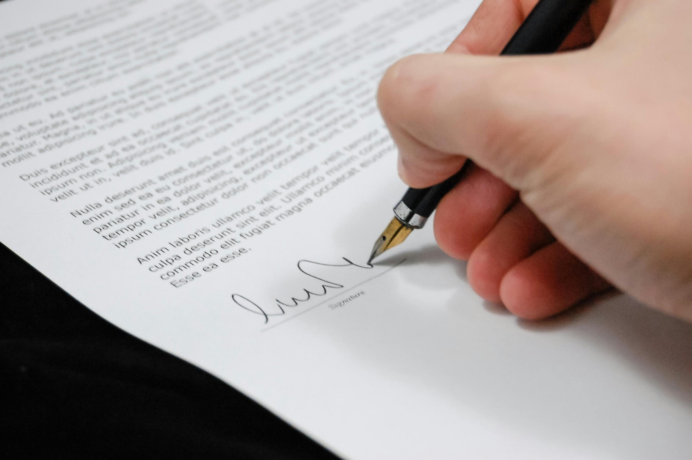 a person signing a paper