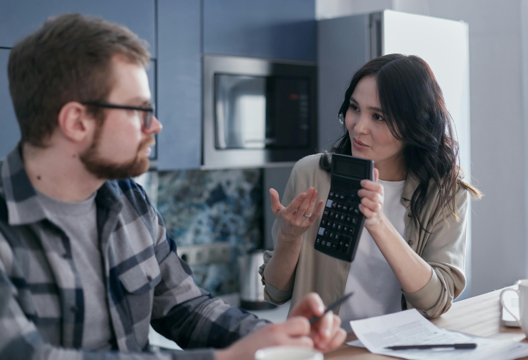 A woman showing a calculator to a man
