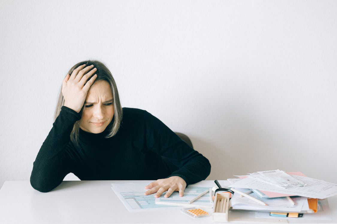 An individual stressed out while navigating financial documentation
