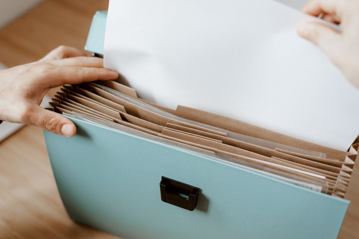 organizing-debt-collection-records Alt text: Hands organizing financial and legal documents in a file folder Image Caption: Keeping creditor records organized can help when reviewing a collection claim
