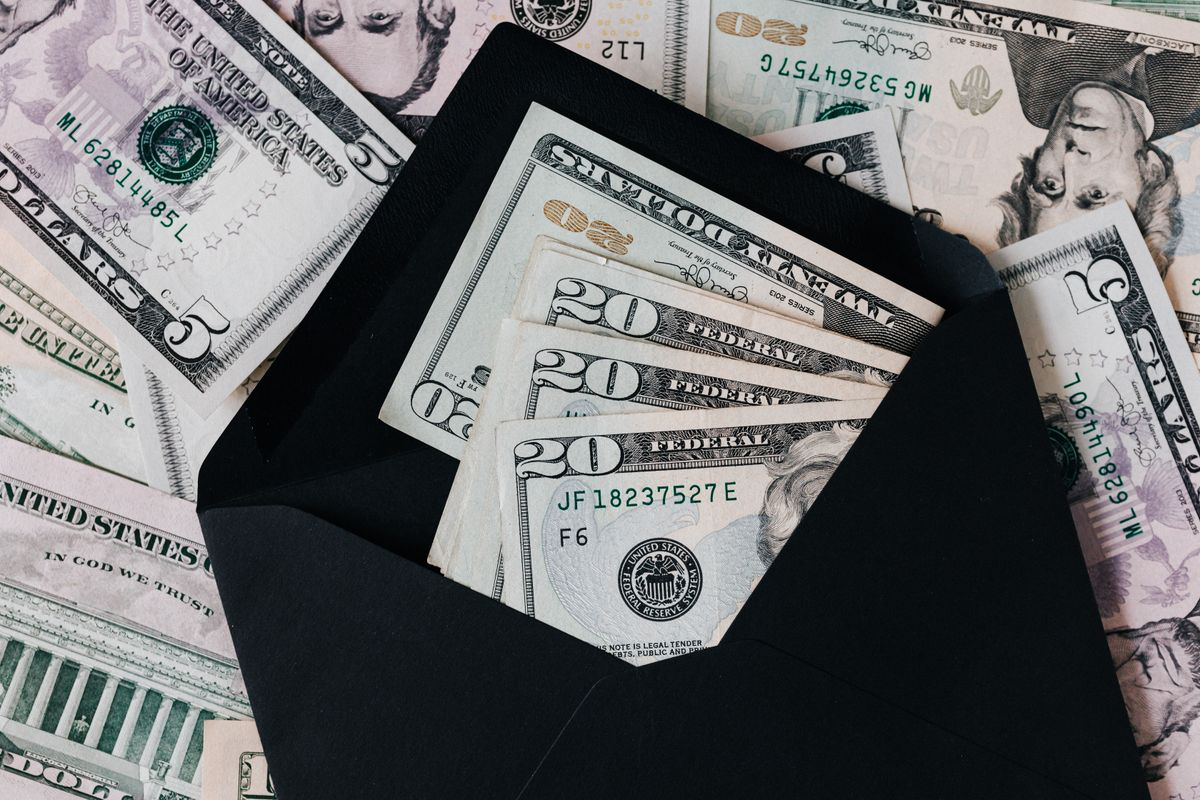reviewing-financial-position Alt text: United States dollar bills arranged inside a black envelope Image Caption: Reviewing income, expenses, and available assets helps clarify realistic debt options